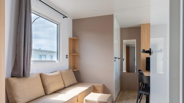 Una habitación moderna con sofá, una mesita y una silla.