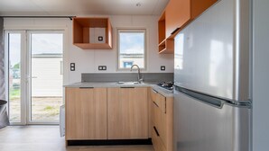 Una cocina moderna con armarios de madera, un refrigerador de acero inoxidable y un ventanal con vistas.