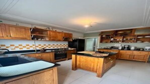 Uma cozinha com armários de madeira, uma ilha central e painel de azulejos.