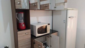 A kitchenette with a microwave, a blender, and a refrigerator. - 001 - Apartment Close to the Center (Vitoria da Conquista)