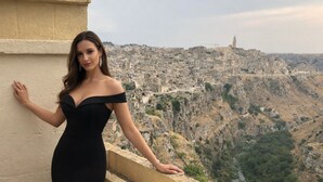A person in a black dress standing on a balcony with a cityscape in the background. - VACATION HOME " THE BELVEDERE ON THE STONES " CIN: IT077014C202430001 (Matera)