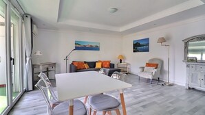 Una habitación amplia con una mesa de comedor, sillas, un sofá y una lámpara.