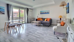 Una sala moderna con un sofá, una mesa de centro y un comedor con sillas.