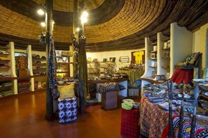 A room with a circular ceiling, shelves with hats, and various textiles. - Lake Manyara Serena Safari Lodge (Lake Manyara National Park)