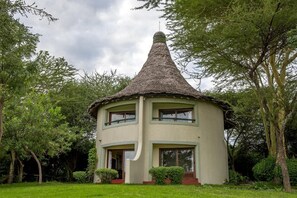 Un petit bâtiment d’un seul étage, surmonté d’un toit conique et entouré d’une végétation luxuriante.
