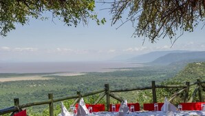 A table set for dining with a view of a valley and a body of water. - Lake Manyara Serena Safari Lodge (Lake Manyara National Park)