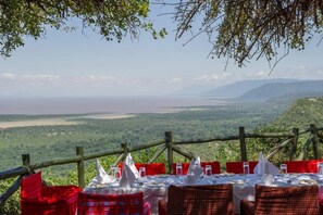 Taula preparada per dinar amb vista a una vall i una massa d'aigua.