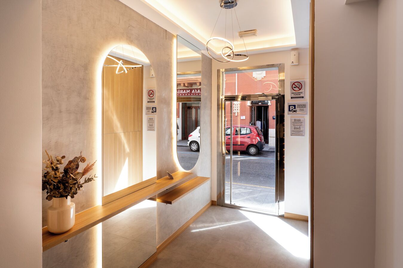 Ein moderner Hotel Eingang mit einer Rezeption, einer Glastür und einem Parkplatzschild.