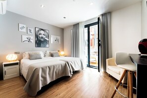 A modern hotel room with a bed, bedside tables, a desk, and a chair. - Infinium Zamora Suites y Apartamentos (Zamora)