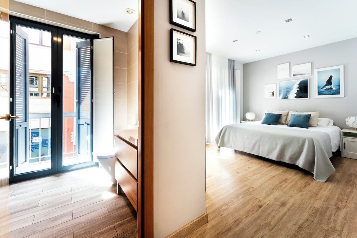 A modern bedroom with a bed, bedside tables, and framed pictures on the wall.