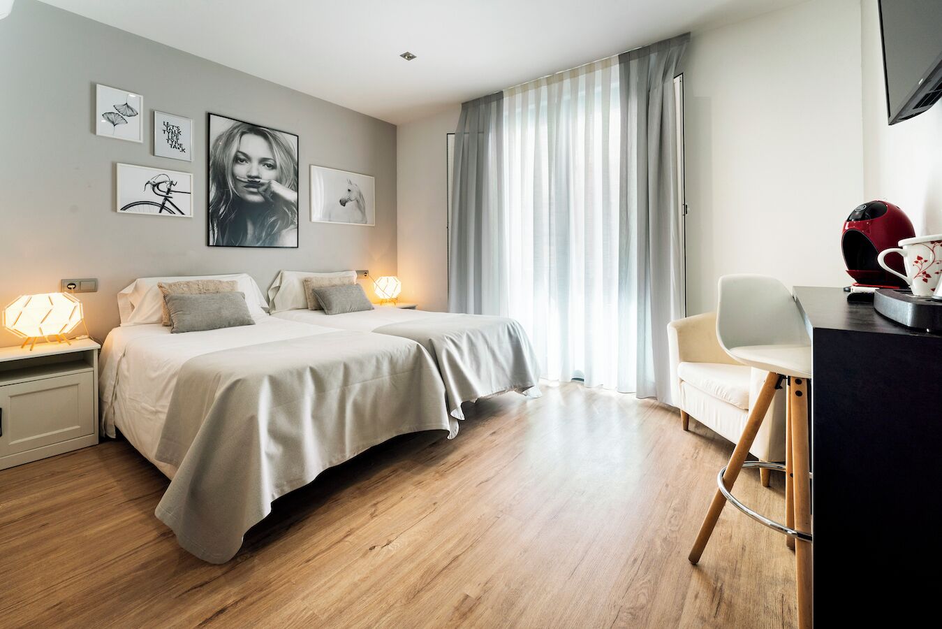 A bedroom with a bed, bedside tables, a desk with a chair, and a window with curtains.