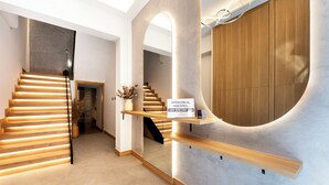 Een modern interieur met een houten trap, een receptiebalie en een vloeiend, gebogen wandontwerp.