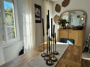 Ein Essbereich mit Holztisch, Teppich und Kerzen.