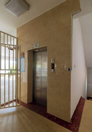 An elevator with a sign indicating the ground floor, a keypad, and a digital display. - Executive two Bedroom in Kilimani (Nairobi)