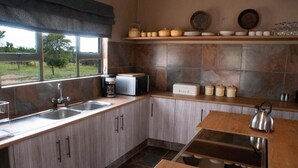 A kitchen with a window, a sink, a kettle, and a bread box. - Casa de la Presa 3 (POLOKWANE)