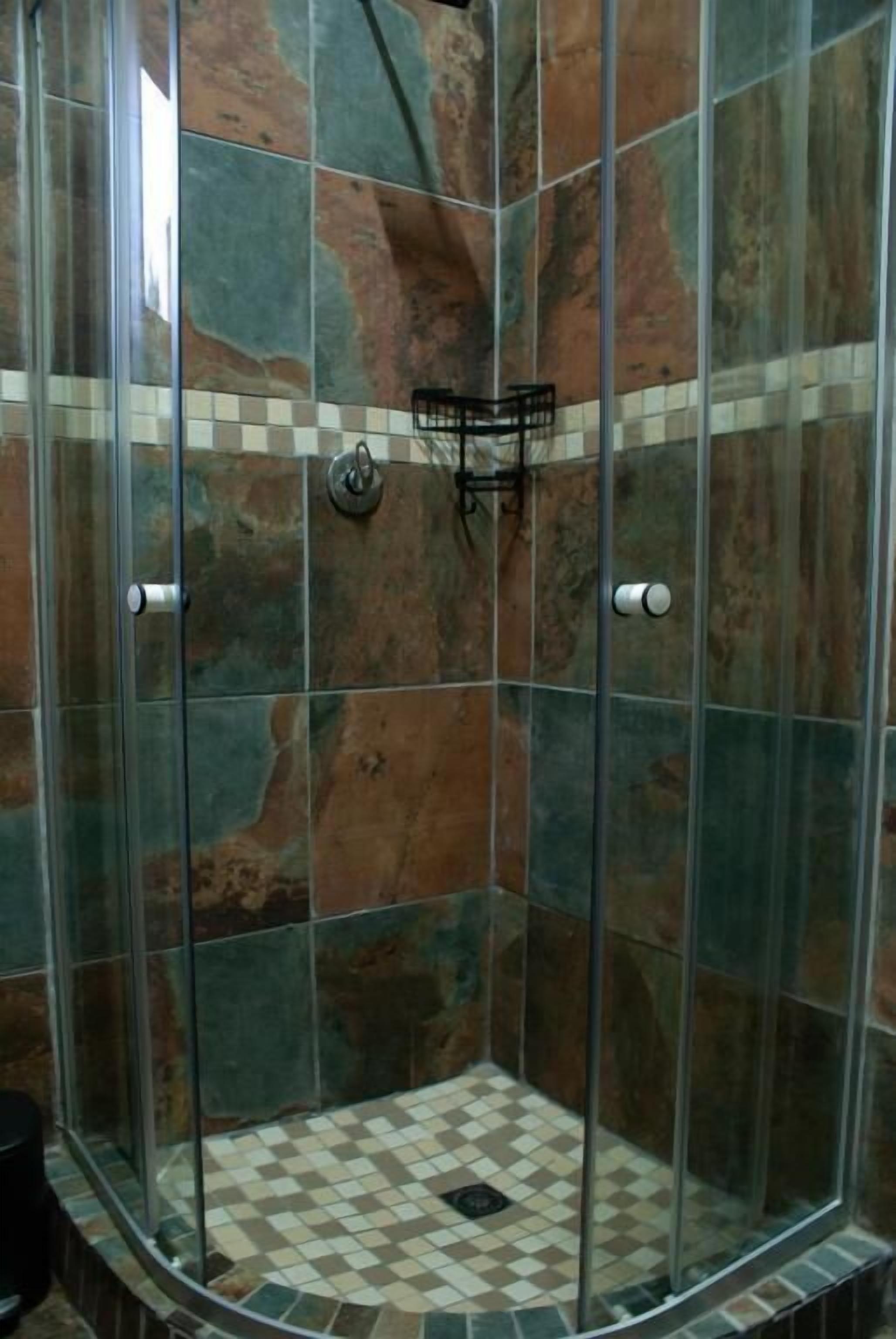 A shower with glass doors and a checkered floor.