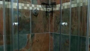 A shower with glass doors and a checkered floor.