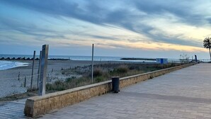 Ein gepflasterter Weg entlang eines Strandes mit blauem Himmel.