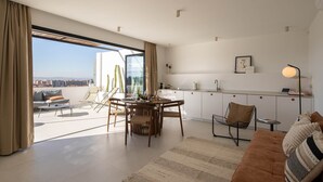 Ein moderner Wohnraum mit Essbereich, einer Couch und einer Küche.