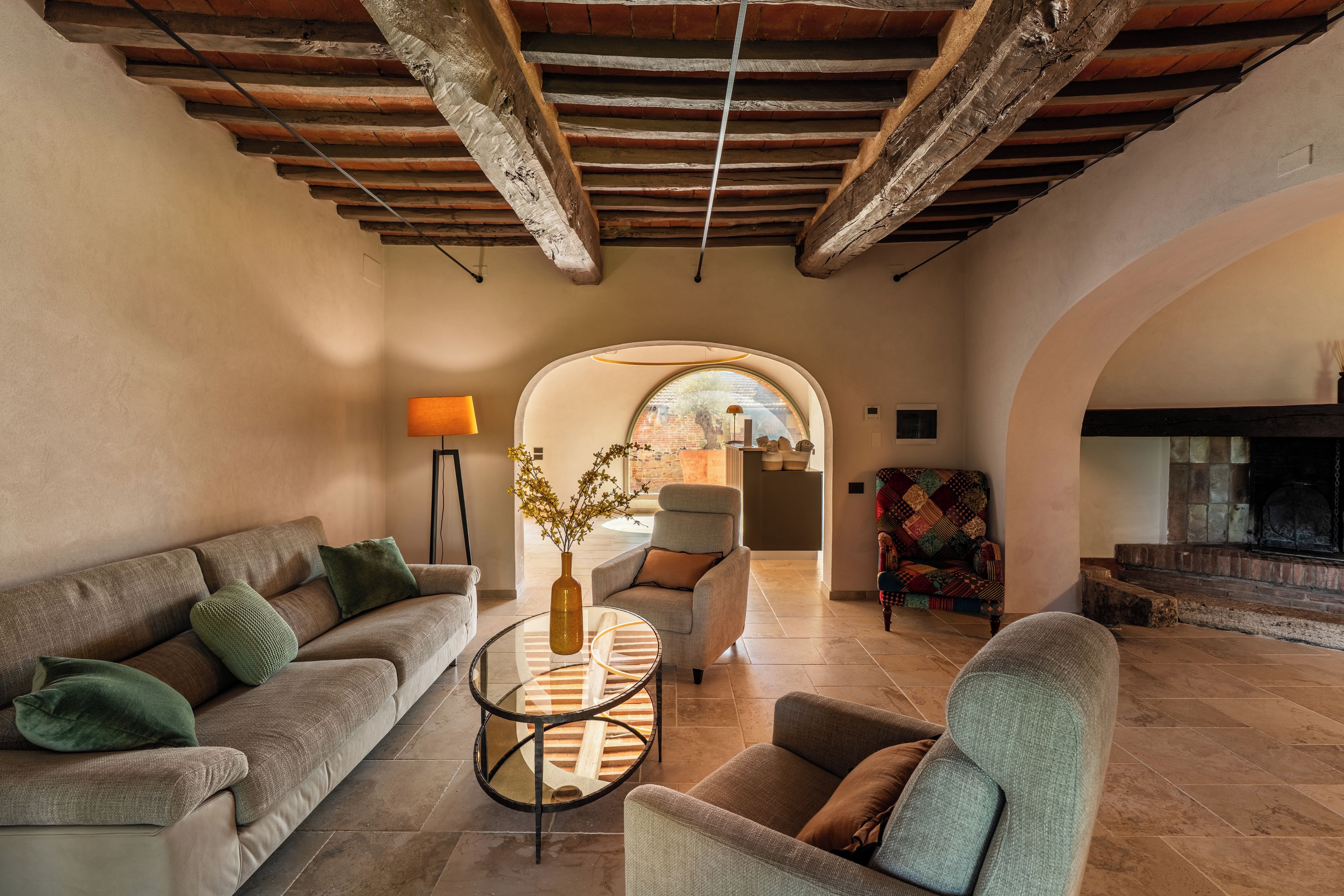 Una sala de estar acogedora con chimenea, un sofá, una mesita de centro y vistas a través de un arco.