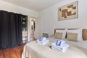 Ein Hotelzimmer mit Bett, einem großen abstrakten Gemälde, einem Badezimmer mit Duschvorhang und Blick ins Badezimmer.