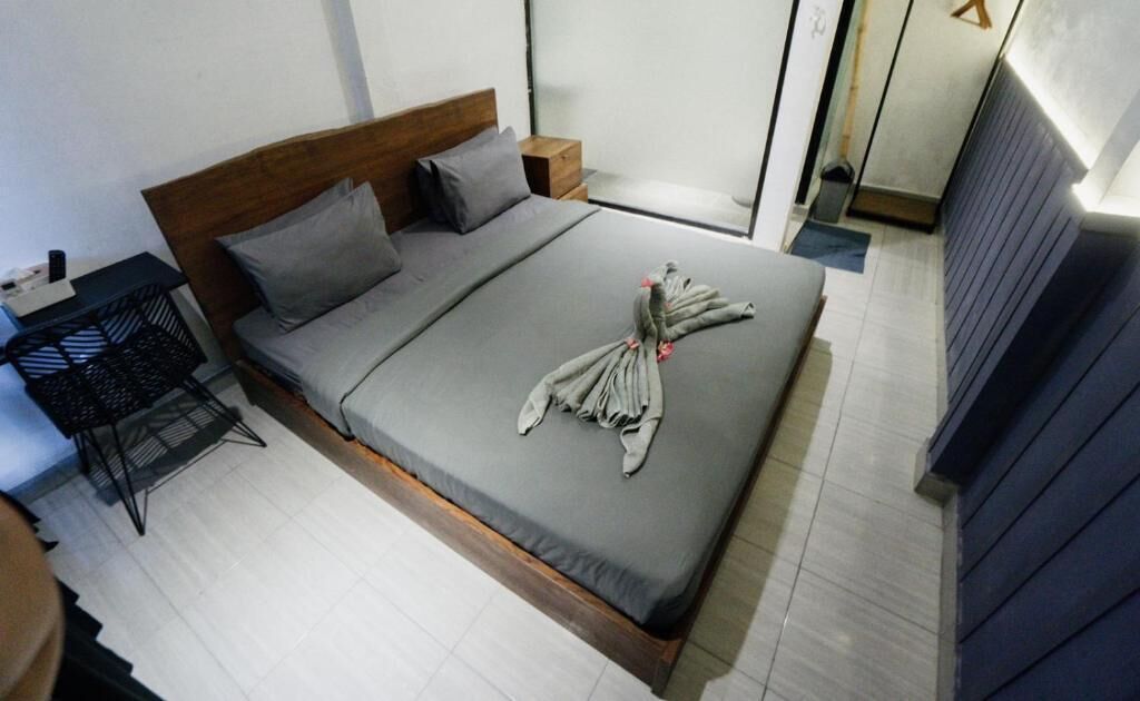 Une chambre d’hôtel moderne avec un lit, une petite table et une chaise.