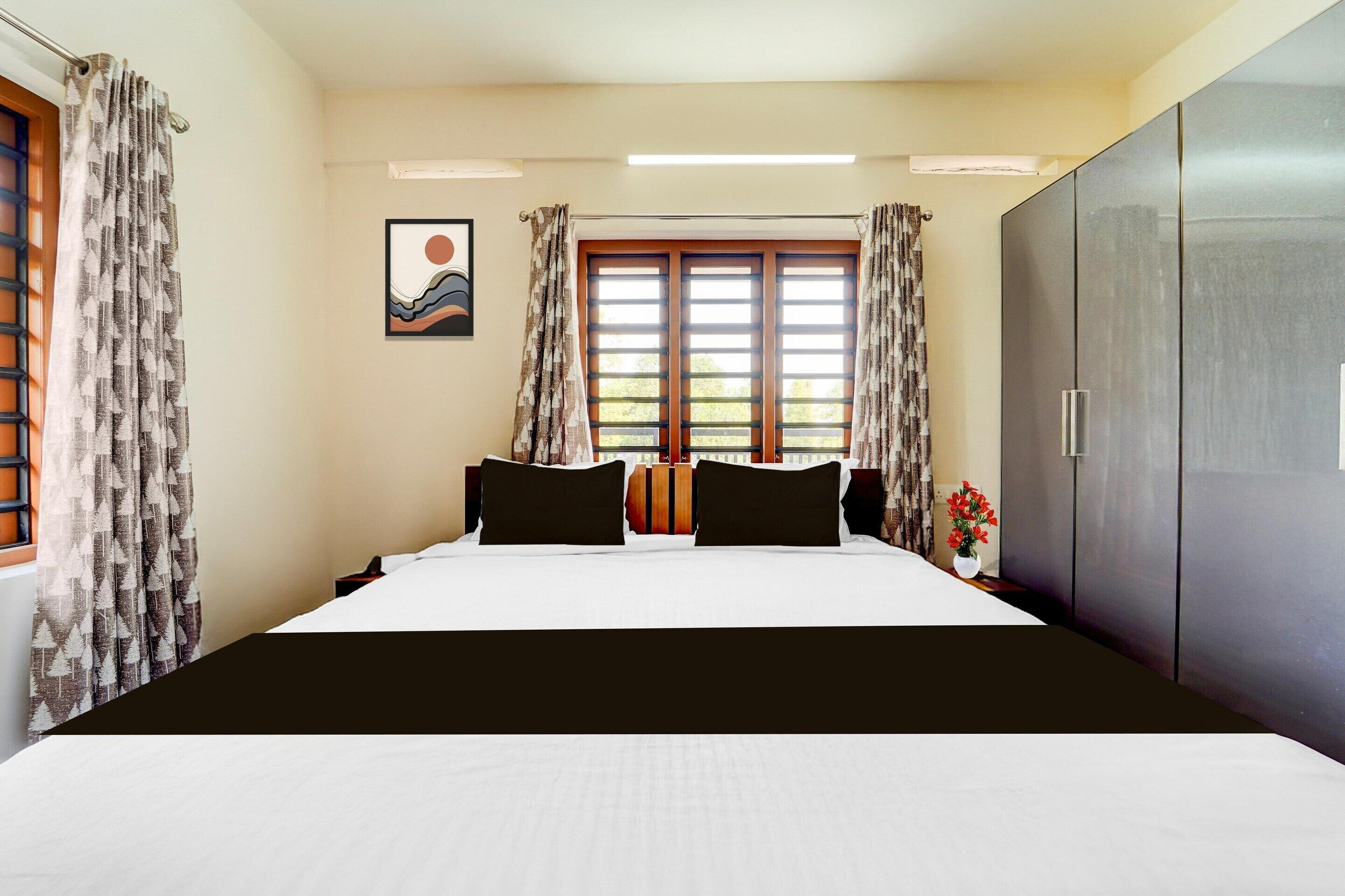 Ein Hotelzimmer mit Bett, Vorhängen, einem Fenster mit Jalousien, einem Kleiderschrank und einem Wandbild.