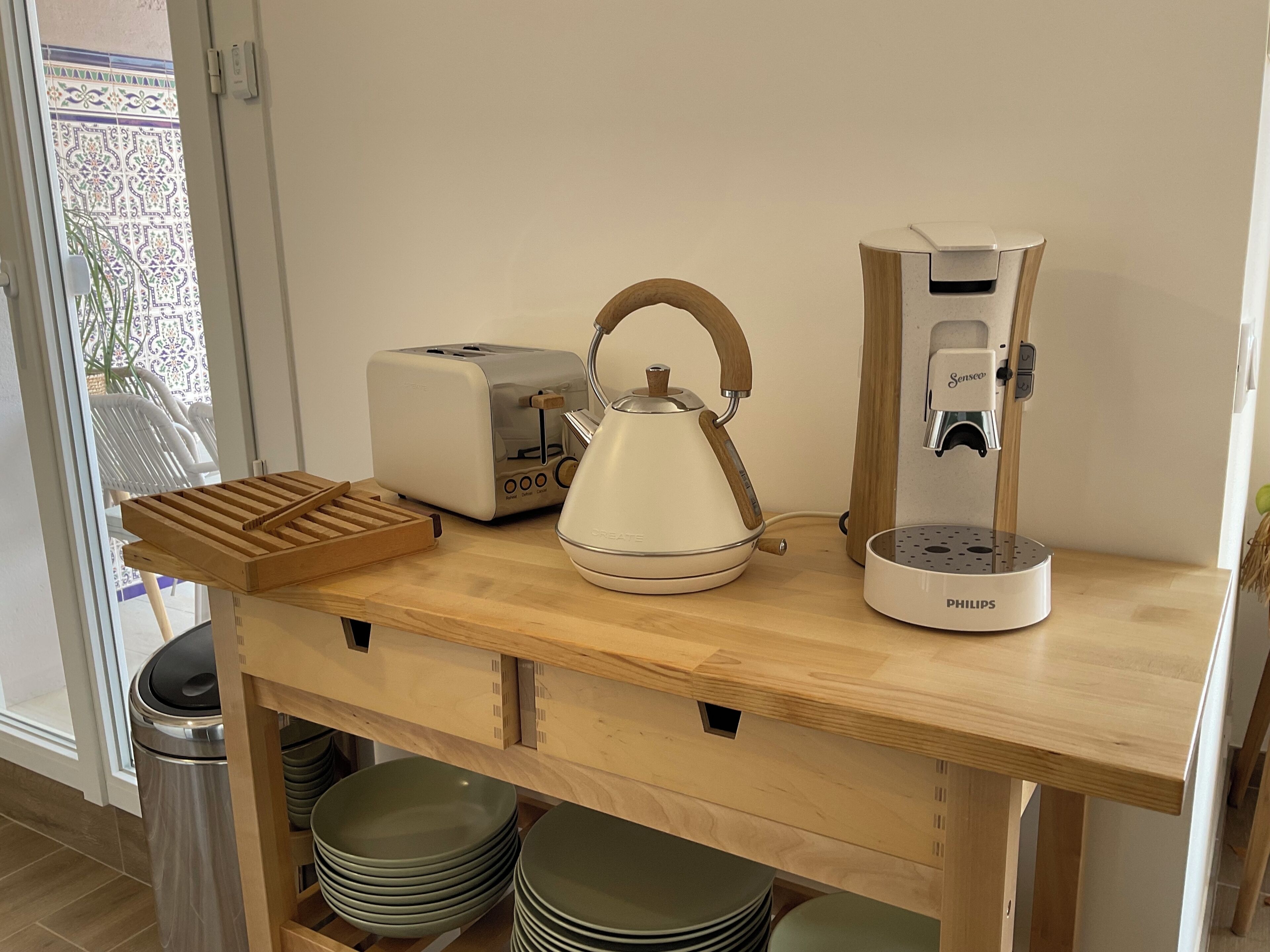 Uma bancada de cozinha com torradeira, chaleira e cafeteira.
