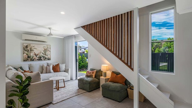 A modern living room with a staircase, a sofa set, a coffee table, and a view of the outdoors. - Mooloolaba Canal Retreat with Pool, Sleeps 12 (Mooloolaba)