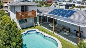 A modern house with a swimming pool, solar panels, and a balcony. - Mooloolaba Canal Retreat with Pool, Sleeps 12 (Mooloolaba)