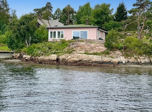 Une maison située sur une côte rocheuse, avec vue sur l’eau.