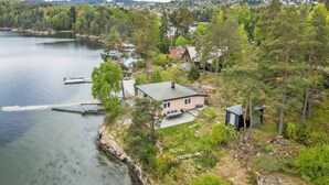 A lakeside property with a house, dock, and surrounding forest. - Waterfront Retreat - Frontline Oslofjord | Small boat included | Fireplace (Akershus)