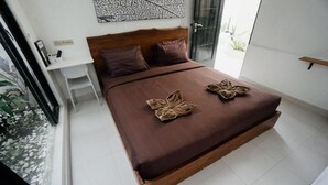 A modern bedroom with a wooden bed, a white desk, and a large window. - Escotel Tempekan Canggu (Tibubeneng)