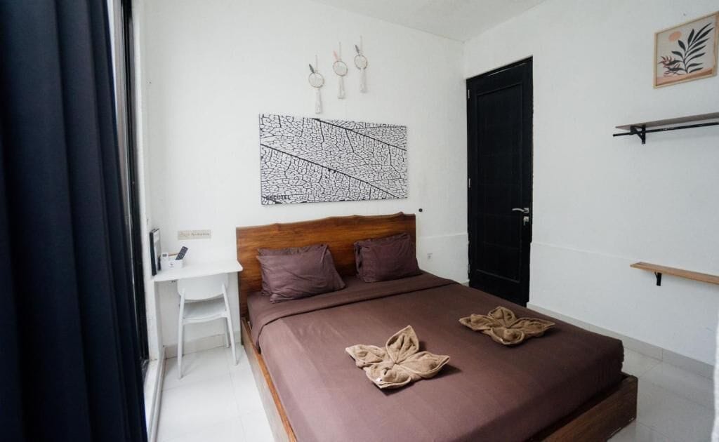 Een slaapkamer met een bed, een bureau en een deur.