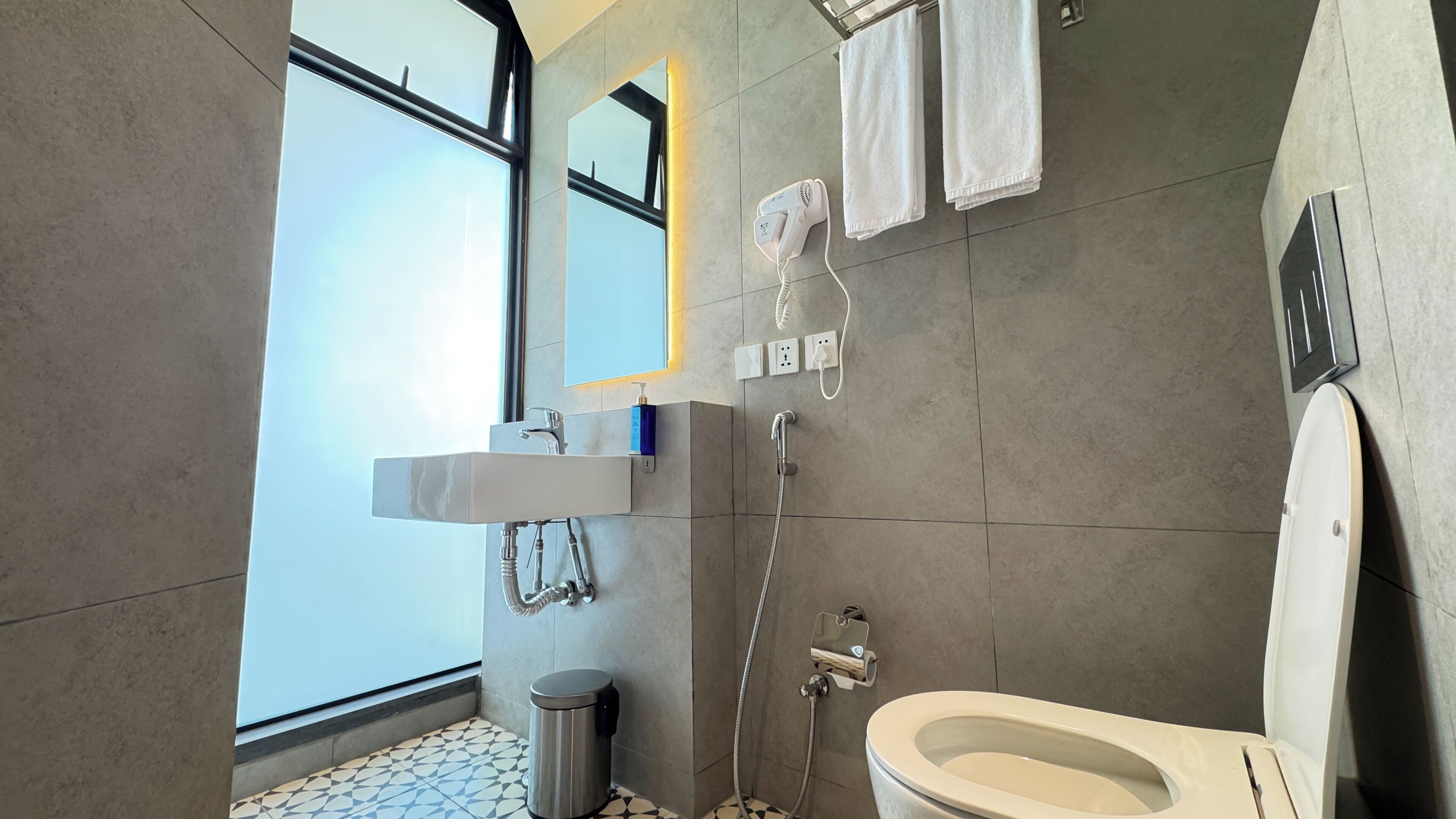 Une salle de bain moderne équipée de toilettes, d’une douche et d’un lavabo.