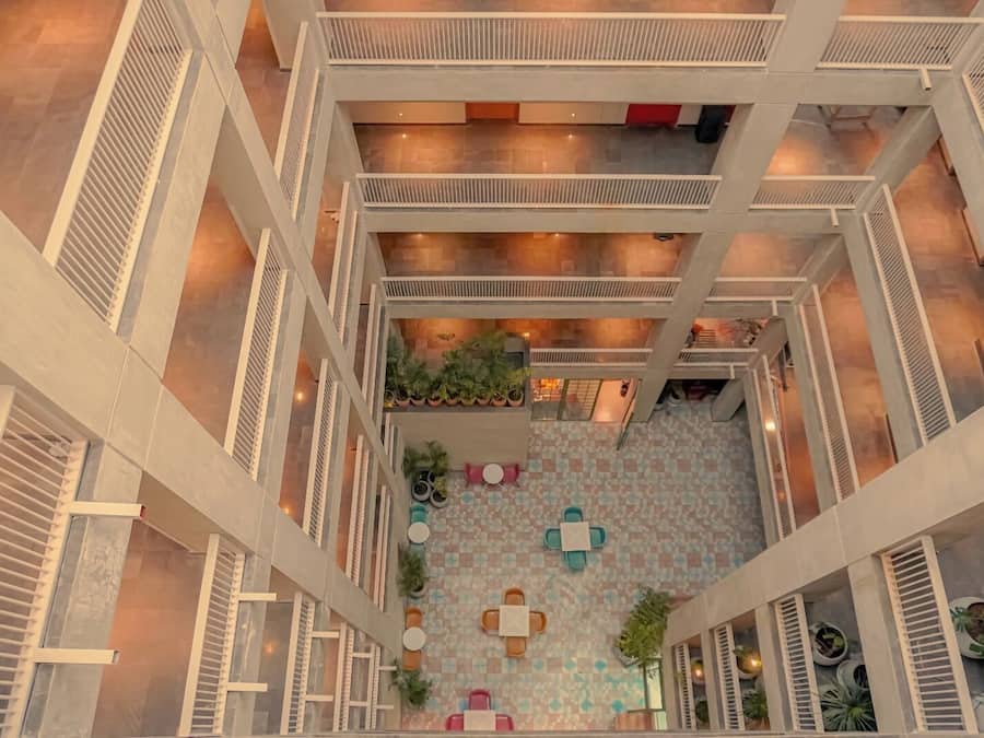 A multi-level atrium with a central open space, railings, and potted plants.