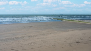 A beach with a sandy shore and the ocean in the background. - Caravan by the sea Blankenberge (Blankenberge)