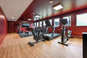 Un gimnasio con cintas de correr, elípticas y máquinas de pesas.
