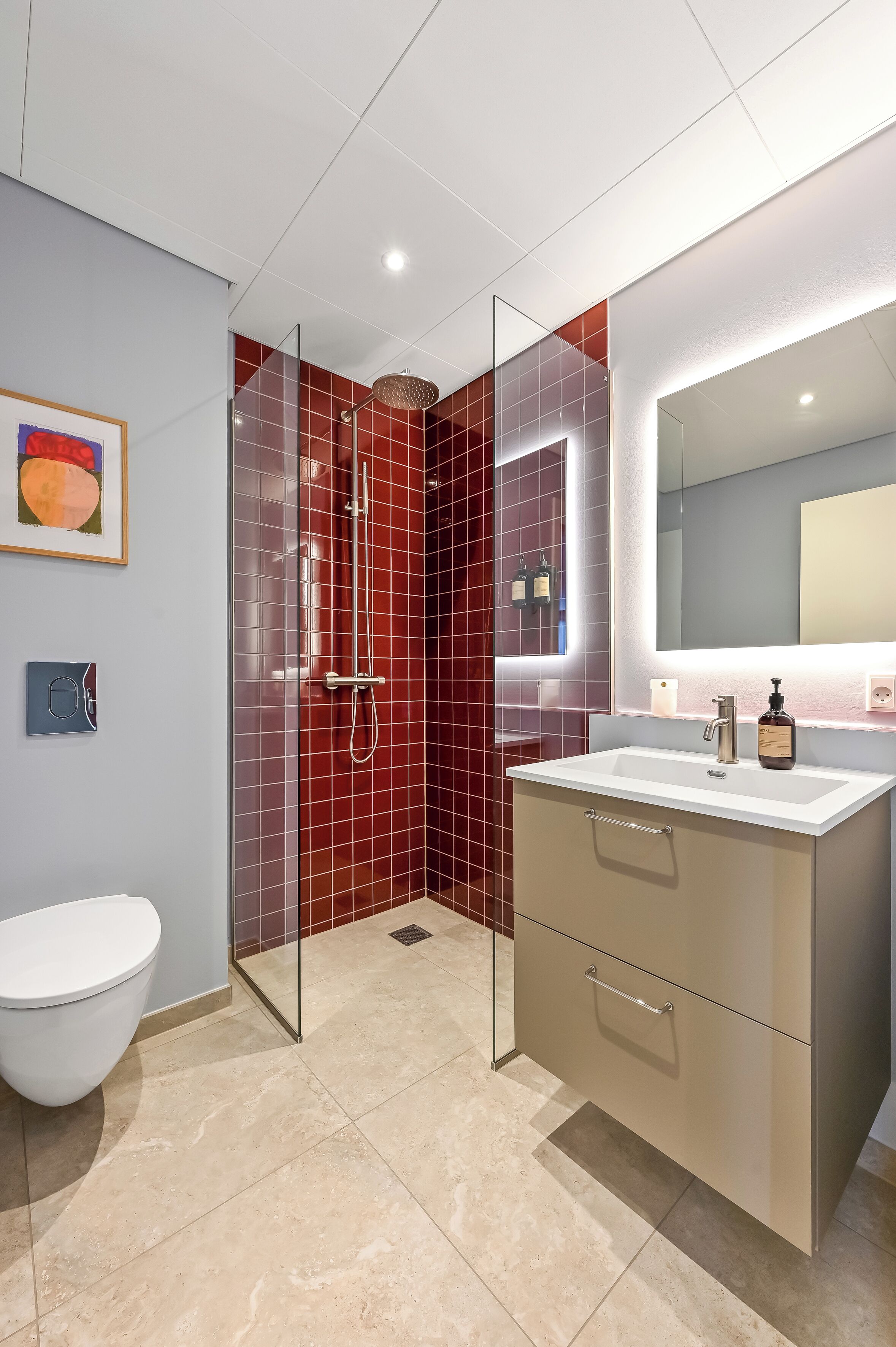A modern bathroom with a glass-enclosed shower, a white toilet, and a vanity with a mirror.