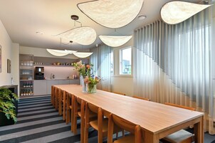 Una cocina moderna con una mesa de comedor de madera, luces colgantes y vistas a la ciudad.