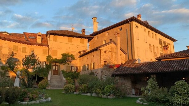 A traditional building with a courtyard, a staircase leading to the entrance, and a small garden area. - Villa Francescon (Borgo Valbelluna)