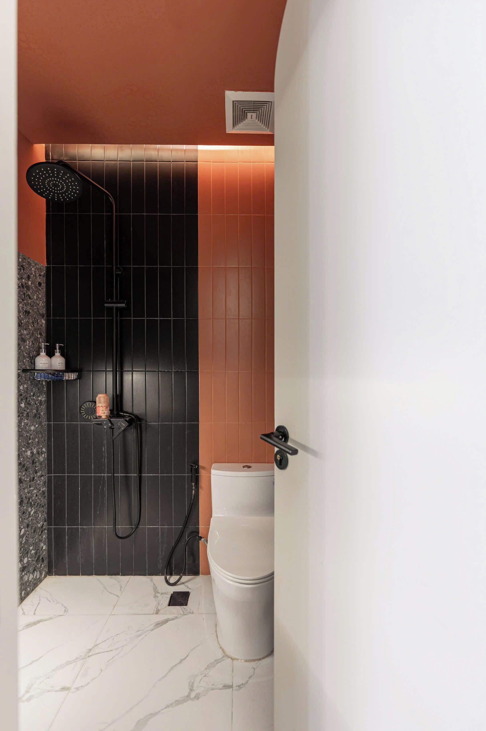 A bathroom with a shower, toilet, and marble floor.