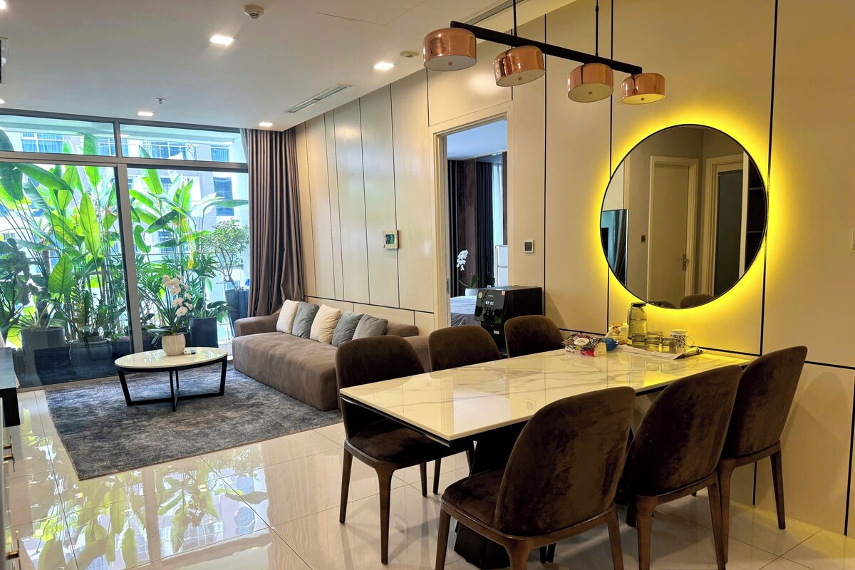 A modern living room with a sofa, coffee table, and dining area with chairs.