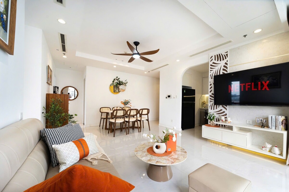 A modern living room with a sofa, coffee table, and a TV mounted on the wall.