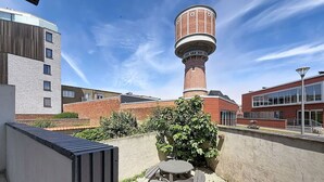 Een binnenplaats met een watertoren, een picknicktafel en een gebouw met grote ramen.