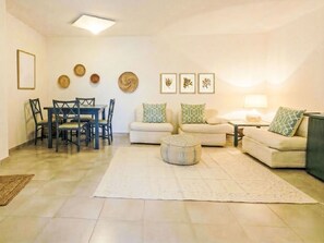 Ein Wohnzimmer mit Esstisch, zwei Sofas, einem Couchtisch und Wanddekoration.