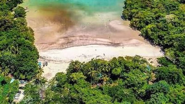 An aerial view of a coastal area with a clear turquoise sea, a sandy beach, and dense green vegetation. - Casa Brisa Caribe Cabrera Perfect for Family & Friends (Cabrera)