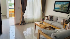 A living room with a sofa, coffee table, and a painting on the wall. - Casa Brisa Caribe Cabrera Perfect for Family & Friends (Cabrera)