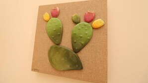 Una pintura de un cactus sobre un lienzo texturizado.
