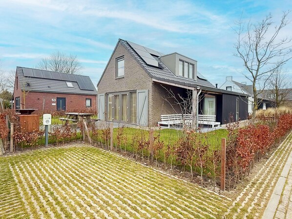 A modern house with a sloped roof, large windows, and a paved driveway. - Holiday Home Near North Sea for 6 (Sint Maarten)